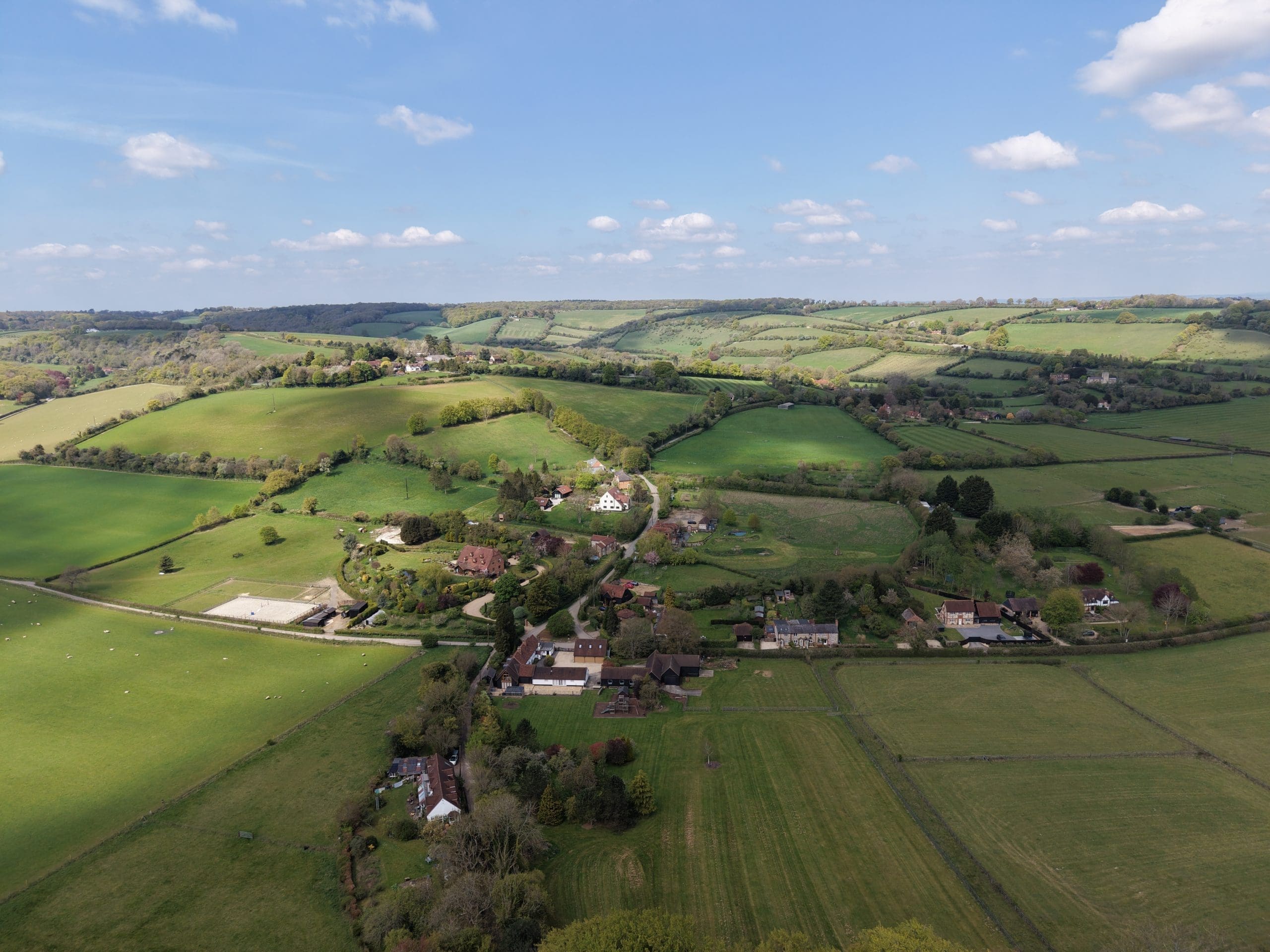 countryside with small village in foreground, rolling hills in the background