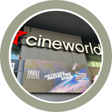Cineworld cinema storefront with an illuminated sign and movie posters in the display window.