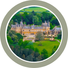 zoomed in image of Waddesdon manor from the distance showing woods and a well maintained lawn in the foreground